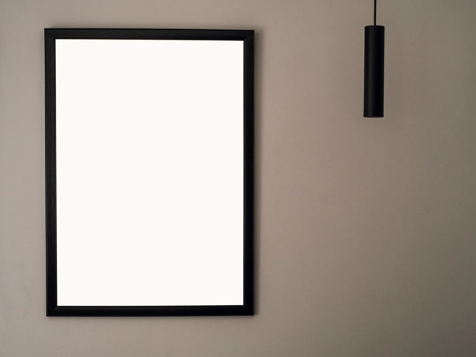 Uma moldura minimalista esta pendurada numa parede interior lisa.