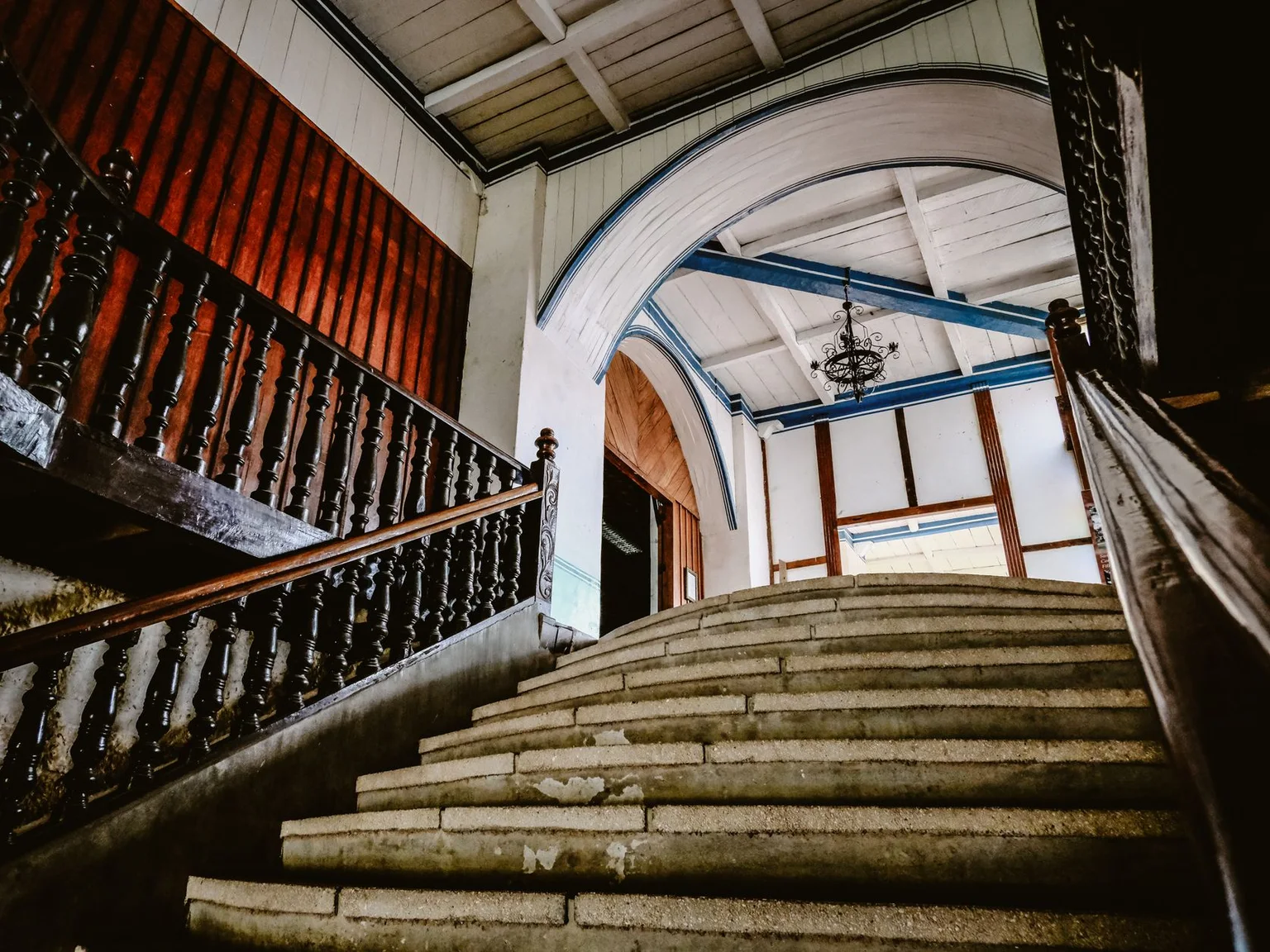 Uma escadaria ornamentada sobe por um interior historico elegante.